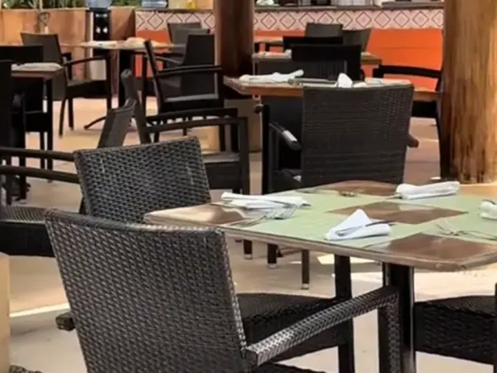 Comedor de un restaurante de playa con mesas y sillas, listo para un servicio de control de plagas